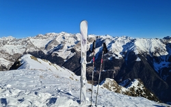 Berge mit Schnee und Skiausrüstung im Vordergrund.