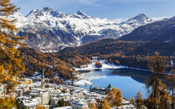 Blick auf das winterliche St. Moritz im Kanton Graubünden, Schweiz, mit dem schneebedeckten St. Moritzersee und den umliegenden Bergen, Teil der Engadiner Seenplatte.