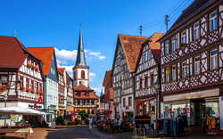 Fachwerkhäuser und Kirche in einer deutschen Altstadt bei Sonnenschein.