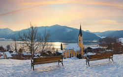 Winterliches Panorama in Schliersee, Bayern mit schneebedeckter Landschaft, Kirche und Alpen im Hintergrund.