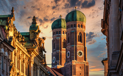 Blick auf die Frauenkirche in München bei Sonnenuntergang.