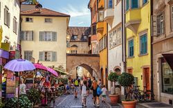 Straßenszene in einer Altstadt mit bunten Gebäuden und Fußgängern