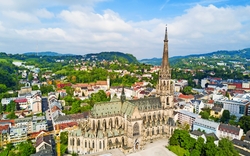 Luftaufnahme einer großen gotischen Kathedrale in einer Stadt mit umliegender Landschaft.