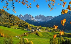 Herbstliche Landschaft mit Bergen und buntem Laub in einem Alpen-Tal.