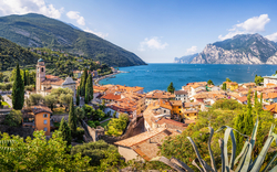 Blick auf eine malerische Stadt am Gardasee mit Bergen im Hintergrund.