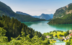 Bergsee in malerischer Landschaft mit Wäldern und Bergen im Hintergrund