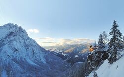 Verschneite Berglandschaft mit Hütte an steilem Hang in den Dolomiten.