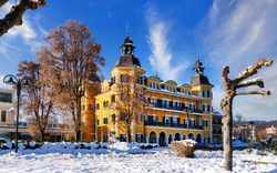 Gelbes Gebäude im Winter mit Schnee und blauem Himmel.