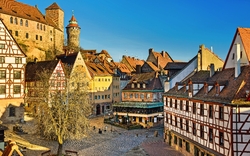 Historische Altstadt mit Fachwerkhäusern und Burg im Hintergrund.