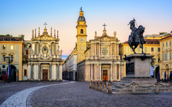 Historischer Platz mit Kirche und Reiterstatue bei Sonnenuntergang.