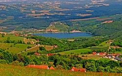 Landschaft mit Hügeln, Dörfern und einem See in der Mitte.