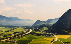 Panoramablick auf eine Alpenlandschaft mit Fluss und Tälern.