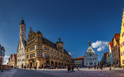 Historischer Marktplatz mit alten Fachwerkhäusern und einem großen Rathaus.