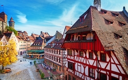 Fachwerkhäuser und Kopfsteinpflaster in einer Altstadt mit blauem Himmel.
