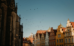 Historische Gebäude und fliegende Vögel im blauen Himmel