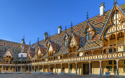 Hospices de Beaune in Burgund, Frankreich mit markantem Dachmuster und Innenhof.